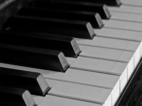 Piano keys of a very well loved and often played piano in monochrome Black and Whit