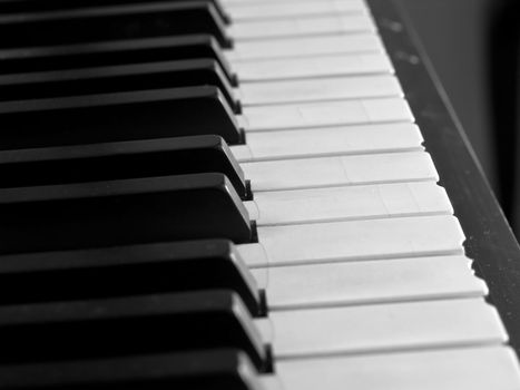 Piano keys of a very well loved and often played piano in monochrome Black and Whit