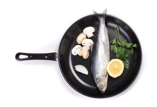 fish in pan with vegetables isolated on white