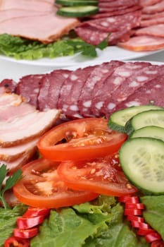 various sliced sausages with vegetables close up