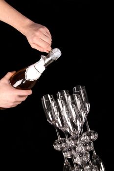 man hands opening champagne bottle isolated on black