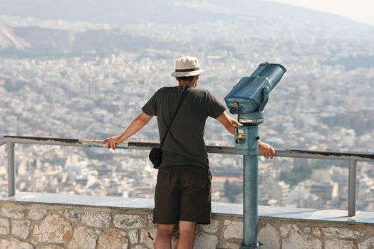 man tourist watching the view of athens from the top of lycabetus