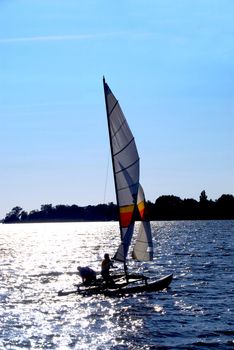 Sailing catamaran backlit