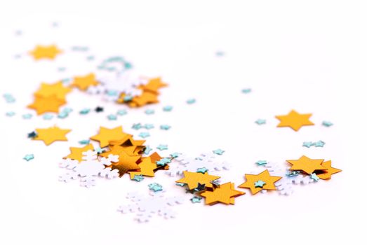Christmas background of scattered gilittering confetti on white