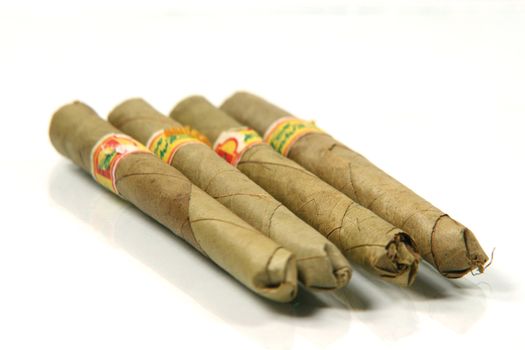 cigars from thailand with banana leaf in white background and reflection