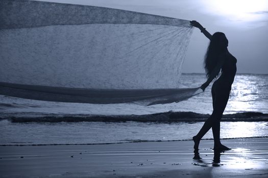 The beautiful woman on a coast on a sunset