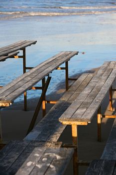 The image of wooden benches on a beach