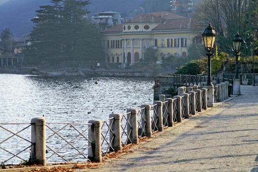 Lakeside walkway with old mansion in the background
