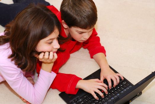 Portrait of brother and sister looking into computer