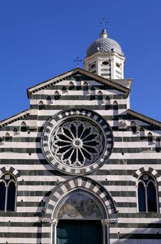Marble striped church front with bell tower behind
