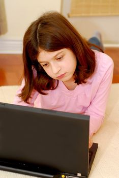 Young girl lying on the floor with portable computer