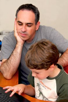 Father teaching his son to work on a computer