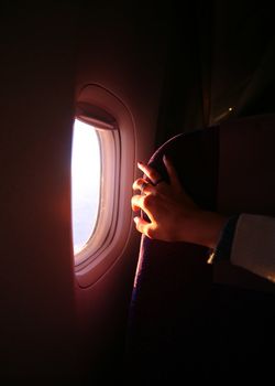 Window of the plane and female hand