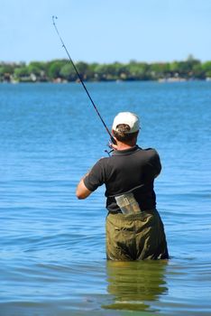 Man fishing in a lake standing in water