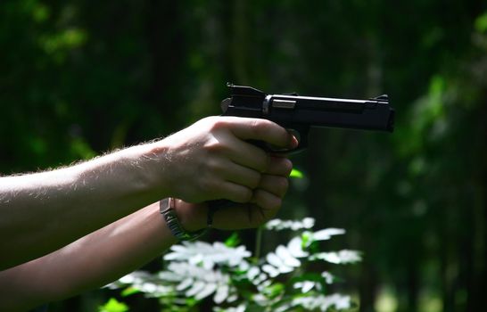 The weapon in a man's hand on a dark background