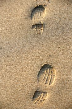 Pair prints of female legs on sand
