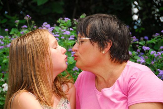 Portrait of grandmother and granddaughter in a garden