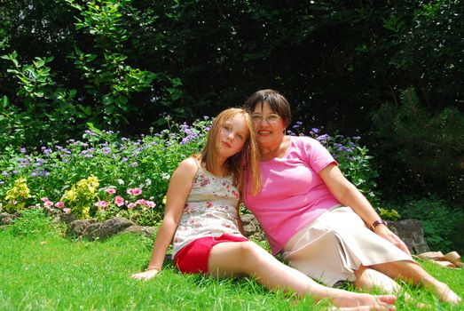 Portrait of grandmother and granddaughter in a garden