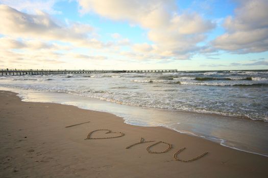 Words about love written on wet sand