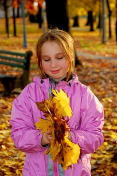 Portrait of a young girl holding autumn leaves