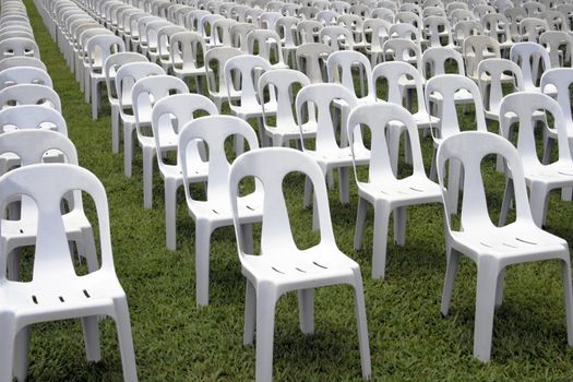 rows and columns of white monoblock chairs
