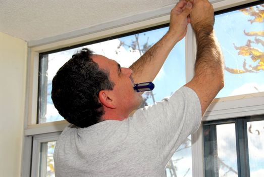 Man installing window blinds in a house 