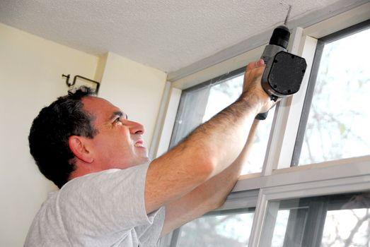 Man drilling a hole in a ceiling