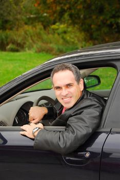 Smiling man looking out of a car window