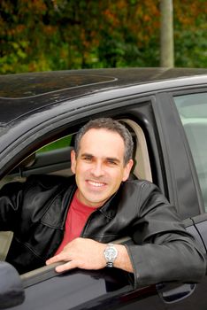 Smiling happy man looking from a car window