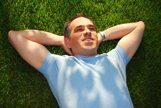 A man lying on green grass relaxing