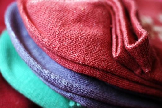 A close-up photograph of a pile of three pairs of socks