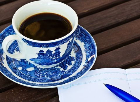 Close up of a cup of coffee on the table with a note