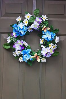 A different colored flowers door wreath  hanging on the door