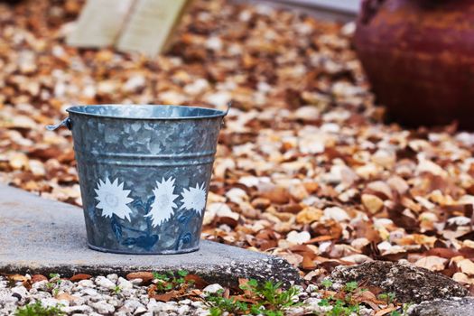 Close up of a grey bucket sitting outside on a rock