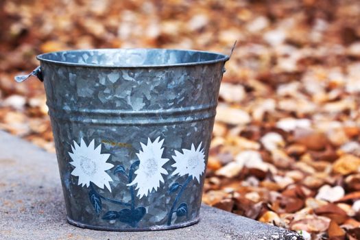 Close up of a grey bucket sitting outside on a rock