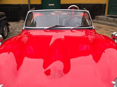 Details of a vintage classical European red sports car