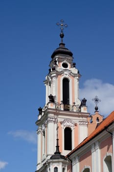 A pink belltawer and blue sky in Vilnius
