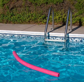 Blue Swimming Pool. Ladder, and Pink Pool Toy in Full Sunlight