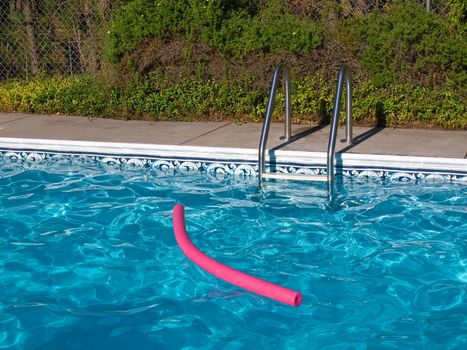 Blue Swimming Pool. Ladder, and Pink Pool Toy in Full Sunlight