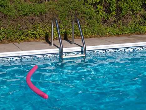 Blue Swimming Pool. Ladder, and Pink Pool Toy in Full Sunlight