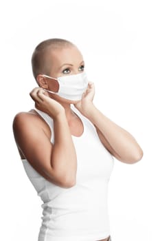 Portrait of nice young woman in surgery mask on white bac
