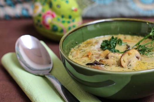 Mushroom soup in a green bowl with a spoon