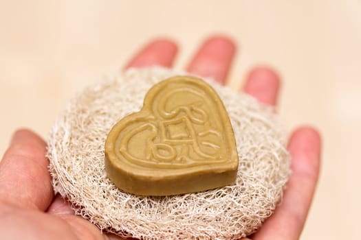 Heart soap on the sponge in a hand