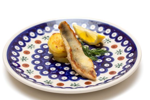 Perch filet with fried potatoes, lemon and dill