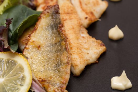 Fried perch filets with potatoes, lemon and salad