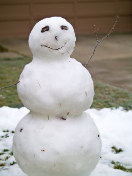 Snowman in the Front Yard of a House after a Little Snowfall