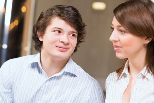 Attractive young man and woman sitting on the floor talking