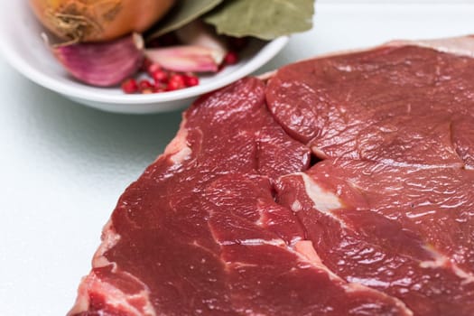 Beef steak with bowl of spices beside for cooking