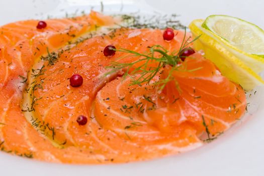 Salmon carpaccio with pink pepper and juice of lemons