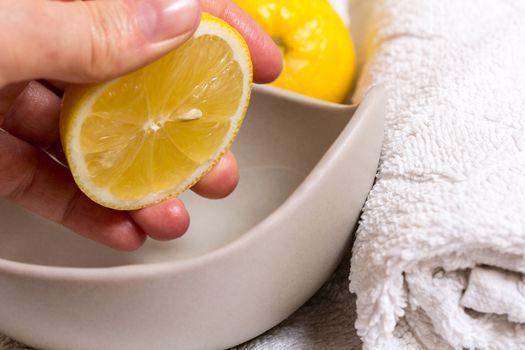 Pressed lemon in wellness by a hand